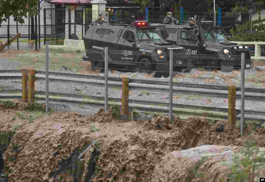 Polisi bersenjata tampak berhenti di jalan yang digenangi banjir di Santiago, Chile.