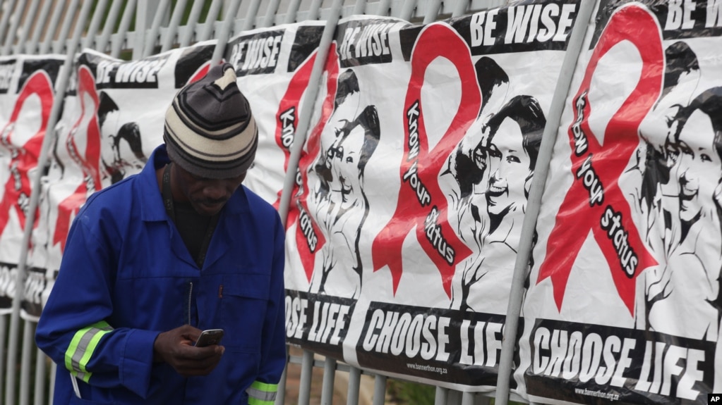 资料照片：一名男子走过南非约翰内斯堡世界艾滋病日的广告（2014年12月1日）(photo:VOA)