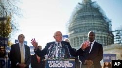 Democratic presidential candidate Sen. Bernie Sanders, center, and Sen. Jeff Merkley (l) announce new climate legislation, Nov. 4, 2015, during a news conference on Capitol Hill in Washington.