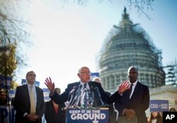 Bakal calon presiden dari Partai Demokrat Sen. Bernie Sanders, tengah, dan Sen. Jeff Merkley (kiri) mengumumkan peraturan iklim baru, 4 November 2015, pada konferensi pers di Capitol Hill di Washington.