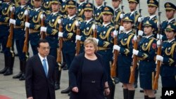 Norwegian Prime Minister Erna Solberg, second from left, walks with Chinese Premier Li Keqiang during a welcome ceremony outside the Great Hall of the People in Beijing, China, April 7, 2017.