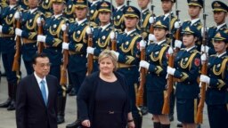 Thủ tướng Na Uy Erna Solberg cùng với Thủ tường Trung quốc Lý Khắc Cường duyệt hàng quân danh dự tại một buổi lễ bên ngoài Đại sảnh Nhân dân ở Bắc Kinh ngày 7/4/2017.