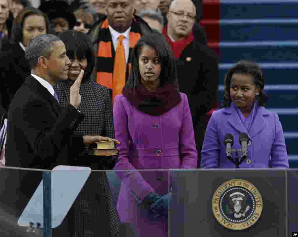 21일 미국 국회의사당에서 열린 대통령 취임식에서 바락 오바마 대통령이 가족들이 지켜보는 가운데 취임선서를 하고 있다.