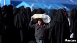 A boy carries bread on his head at al-Hol displacement camp in Syria, April 2, 2019.