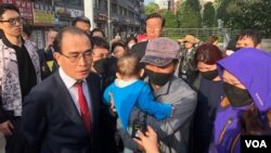 Thae Yong Ho, a former North Korean diplomat, translates for the family of a nine-year-old girl who was detained in China. (B. Gallo/VOA)
