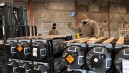 Airmen and civilians load ammunition, weapons and other equipment bound for Ukraine at Dover Air Force Base, Delaware, Jan. 21, 2022.