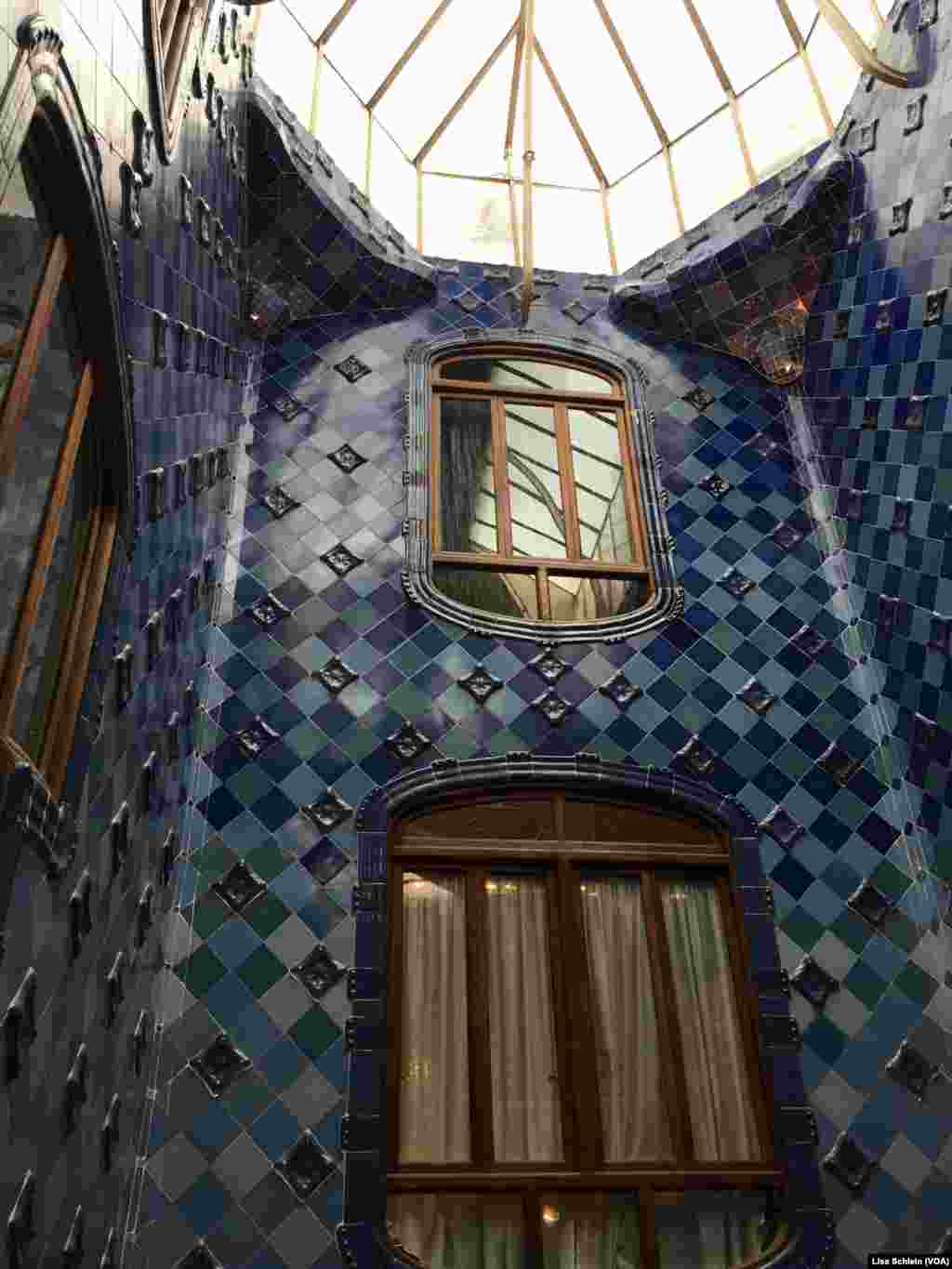Langit-langit kaca yang besar menyinari ubin biru tua di lantai atas Casa Batllo di Barcelona.