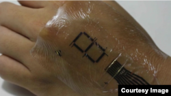 Peneliti Jepang sedang menguji "kulit elektronik," disebut e-skin (foto: Laboratorium Someya).
