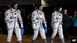 Dari kiri: Astronot NASA Jeff Williams, Kosmonot Rusia Alexei Ovchinin, dan Oleg Skripochka bersiap menuju pesawat antariksa Soyuz TMA-20M yang akan membawa mereka ke Pesawat Antariksa Internasional (ISS) dari kosmodrome Baikonur (19/3). 