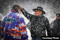 Photo shows cultural advisor Craig Falcon (R) blessing Roger Vielle, both members of Blackfeet tribe, during a Vietnam veterans retreat on the Blackfeet Reservation in Montana, September 2017. Courtesy, Wingspan Media Productions.