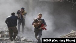 Warga sipil berusaha menyelamatkan diri dan keluarganya di tengah berkecamuknya pertempuran di Ghouta Timur, Suriah (foto: ilustrasi). 