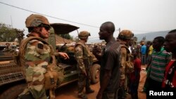 FILE - Angry young men complain to French soldiers in patrol in the pro-Christian area of Bangui, Feb. 15, 2014.