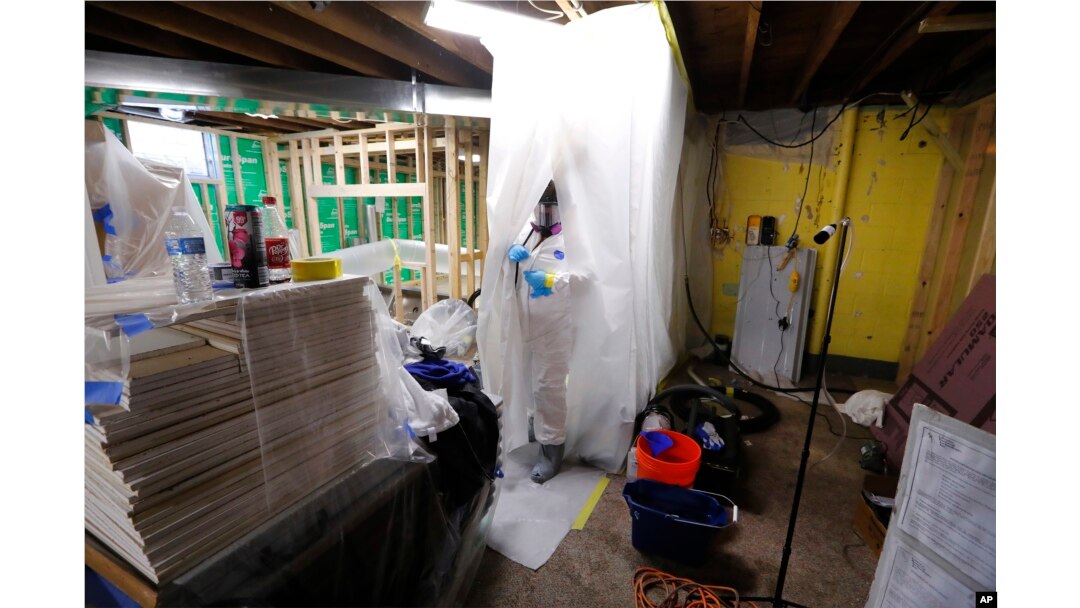 An Asbestos Removal Technologies Inc. technician is seen preparing an area for asbestos abatement in Howell, Michigan, Oct. 18, 2017.