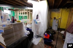 An Asbestos Removal Technologies Inc. technician is seen preparing an area for asbestos abatement in Howell, Michigan, Oct. 18, 2017.