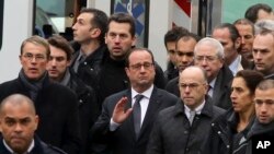 Presiden Perancis Francois Hollande (tengah), dikawal ketat oleh pasukan keamanan, mengunjungi kantor tabloid Charlie Hebdo pasca serangan, Rabu (7/1).