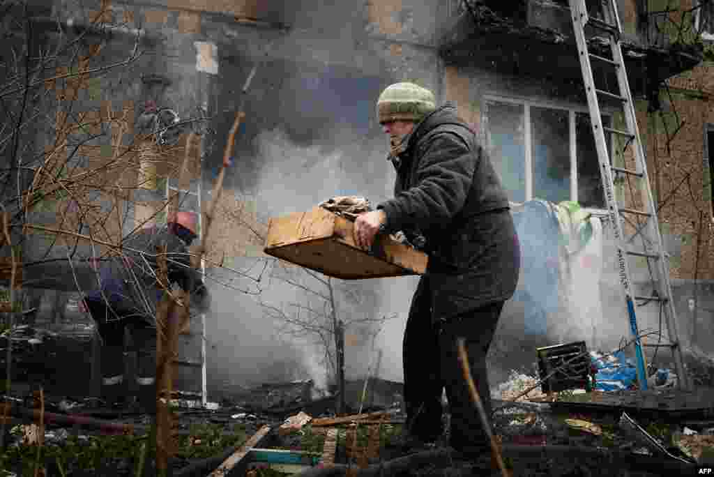 Residents try to save their belongings from a heavily damaged building after shelling between pro-Russian rebels and Ukrainian forces in Donetsk, eastern Ukraine.