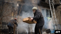 烏克蘭東部居民區遭親俄分離分子砲擊後，在大樓外執拾物件。