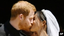 Le prince Harry et Meghan Markle s'embrassent sur les marches de la chapelle St George au château de Windsor après leur mariage à Windsor, près de Londres, Angleterre, 19 mai 2018. 