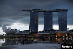 Penggemar fotografi berfoto di Merlion Park di Singapura saat negara kota membuka kembali perekonomian di tengah wabah COVID-19, 19 Juni 2020. (Foto: REUTERS/Edgar Su)