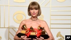 Taylor Swift poses in the press room with the awards for album of the year for 1989, pop vocal album for 1989 and best music video for "Bad Blood" at the 58th annual Grammy Awards at the Staples Center on Monday, Feb. 15, 2016, in Los Angeles. (Photo by Chris Pizzello/Invision/AP)