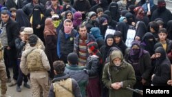 FILE - Displaced Iraqis from Mosul, who are fleeing from Islamic State militants, gather to receive aid in the east of Mosul, Iraq, Dec. 21, 2016.