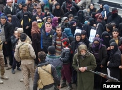 FILE - Displaced Iraqis from Mosul, who are fleeing from Islamic State militants, gather to receive aid in the east of Mosul, Iraq, Dec. 21, 2016.