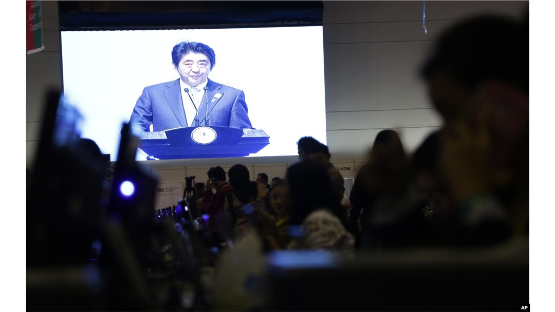 A projection screen shows Japanese Prime Minister Shinzo Abe deliver his speech during a plenary session at the Asia-Africa Summit in Jakarta, Indonesia, April 22, 2015.