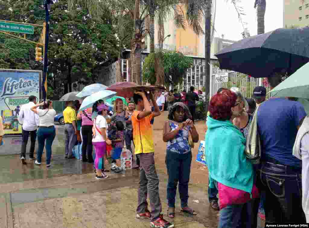 Bajo la lluvia o el sol los venezolanos esperan por horas en la fila para comprar los productos que se encuentran escasos.