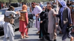 A member of the Taliban forces points his gun at protesters, as Afghan demonstrators shout slogans during an anti-Pakistan protest, near the Pakistan embassy in Kabul, Afghanistan September 7, 2021.