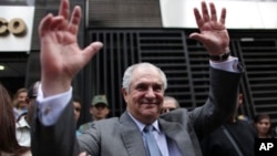 Guillermo Zuloaga, president of Globovision, a private television station opposed to President Hugo Chavez, waves to supporters as he leaves the attorney general's office in Caracas, 4 June 2009