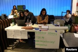 FILE - Volunteer immigration attorneys organize to help as people gather to protest against President Donald Trump's executive order travel ban at Los Angeles International Airport, Jan. 31, 2017.