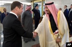 Russian Prime Minister Dmitry Medvedev, left, shakes hands with Saudi Arabia's King Salman during a meeting in Moscow, Russia, Oct. 6, 2017.