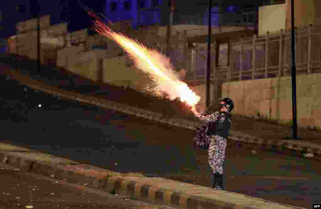 Jordanian security forces disperse a protest in Amman, March 15, 2021, over measures imposed by authorities to curb the spread of the Covid-19.