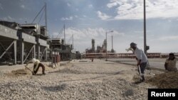 Iranian laborers work at a unit of South Pars gas field in Asalouyeh Seaport, north of Persian Gulf, Iran, Nov. 19, 2015. China's state-owned CNPC energy company now owns 80 percent of the project's share after Total dropped out because of U.S. sanctions.