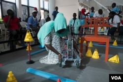 Marieme Toure, from Dakar, adjusts her team's robot at the 2017 Pan-African Robotics Competition in Dakar, Senegal, May 19, 2017. (R.Shryock/VOA)