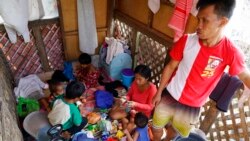 Alona Nacua, right seated, eats with her family as they stay at the house of their neighbor after their home got damaged due to Typhoon Rai in Cebu city, Philippines on Christmas Day, Dec. 25, 2021.