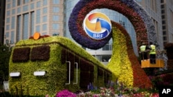 Workers on a platform install flowers on a display in a shape of a train to promoting the upcoming Belt and Road Forum (BRF) in Beijing, China, April 23, 2019.