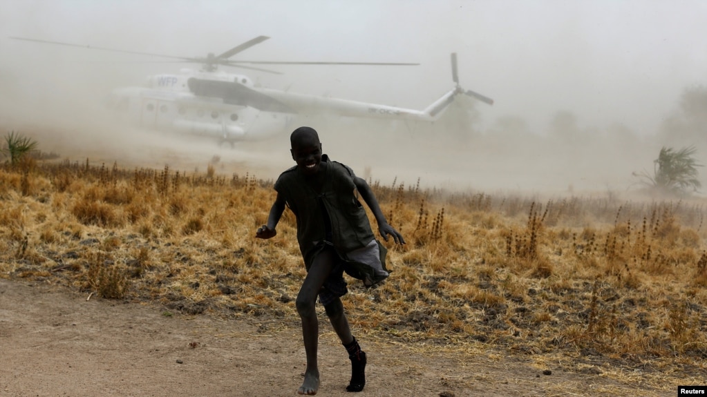 A boy moves away as a United Nations World Food Programme (WFP) helicopter lands in Rubkuai village, Unity State, northern South Sudan, February 18, 2017.