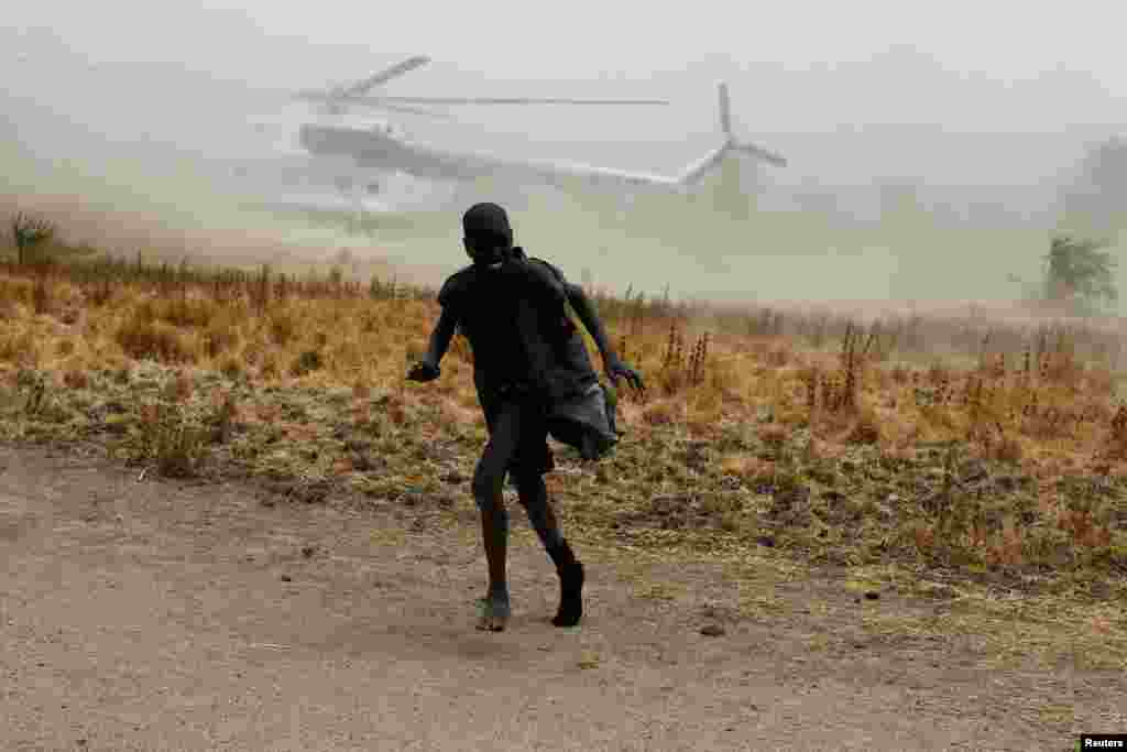 A boy moves away as a United Nations World Food Programme (WFP) helicopter lands in Rubkuai village, Unity State, northern South Sudan.