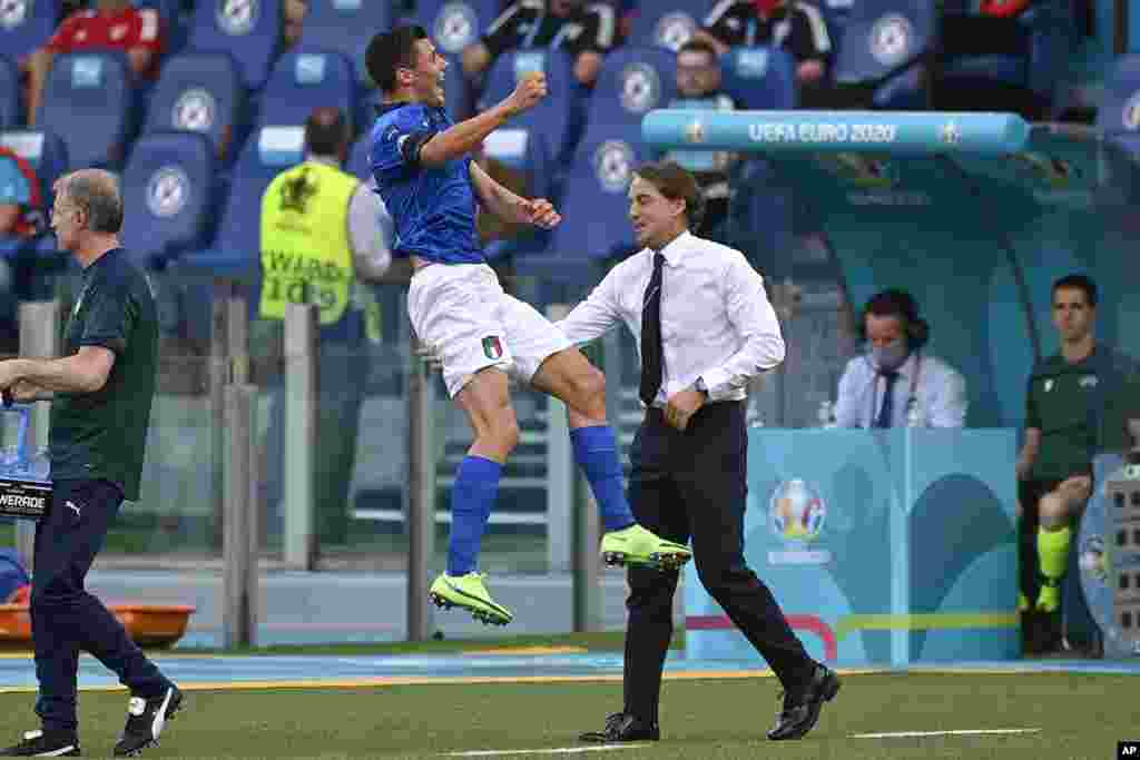 Italy&#39;s Matteo Pessina celebrates with coach Roberto Mancini after scoring his side&#39;s opening goal during the Euro 2020 soccer championship group A match between Italy and Wales, at the Rome Olympic stadium, Italy.