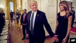 El presidente Donald Trump y su esposa Melania llegan a la recepción para senadores y sus cónyuges en la Casa Blanca.