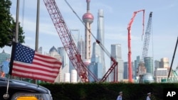 2019年7月30日星期二，中國上海交通警察走過一輛飄著美國國旗的大使館汽車。