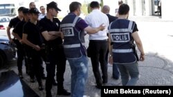 Police officers frisk an employee of the Koza Ipek Group during a raid at the company's office in Ankara, Turkey, September 1, 2015. Turkish police raided the offices of the conglomerate with close links to U.S.-based Muslim cleric Fethullah Gulen, an all