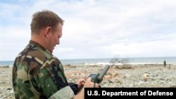 File -- Navy Chief Warrant Officer Paul Patterson calculates coordinates for a potential amphibious landing zone near Makuto, Venezuela, Jan. 3, 2000. 