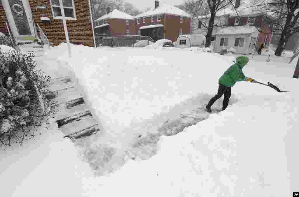 Les habitants de Parkville, dans le Maryland, déneigent l'extérieur de leur maison, le 23 janvier 2016. (AP Photo/Steve Ruark)