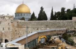 Buldoser melakukan penggalian di depan Masjid Kubah Batu atau the Dome of the Rock (kiri atas) di kompleks Masjid al Aqsa di kota tua Yerusalem 7 Februari 2007. (Foto: REUTERS/Ammar Awad)