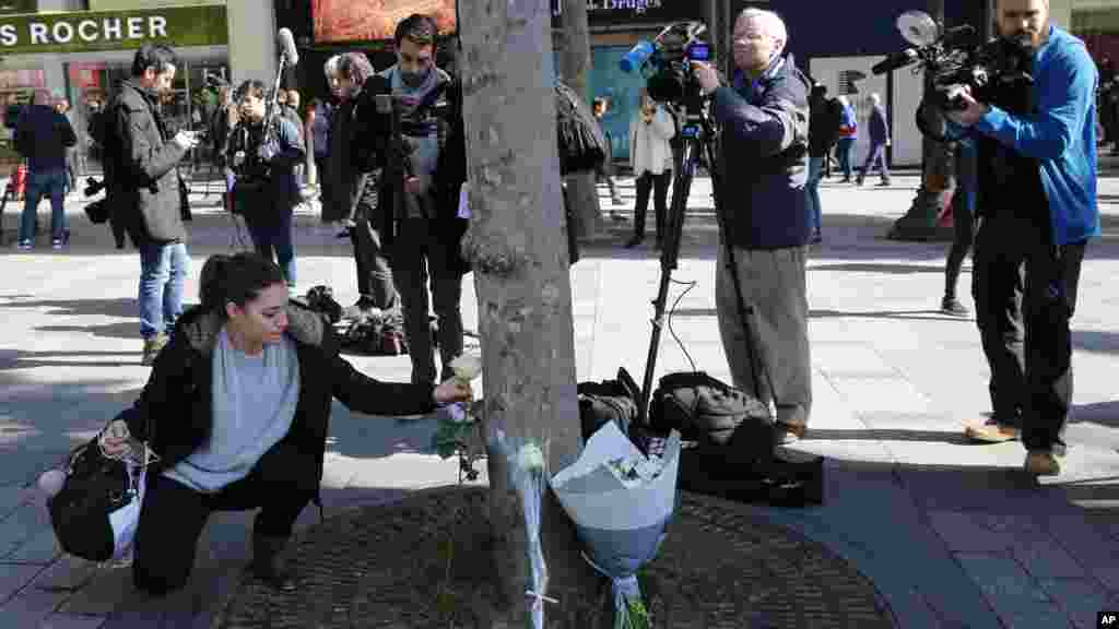 Une dame dépose une fleur à l'endroit où un policier a été tué par un assaillant sur les Champs-Elysées, le 21 avril 2017.