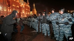 FILE - A man speaks to police at an unsanctioned protest in Moscow, Russia, Dec. 30, 2014.