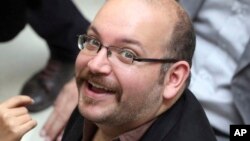 FILE - Jason Rezaian, an Iranian-American correspondent for the Washington Post, smiles as he attends a presidential campaign of President Hassan Rouhani in Tehran, April 11, 2013.