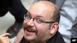 FILE - Jason Rezaian, an Iranian-American correspondent for the Washington Post, smiles as he attends a presidential campaign of President Hassan Rouhani in Tehran, April 11, 2013.